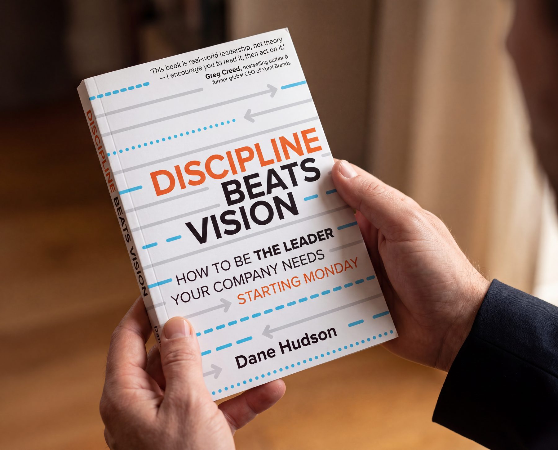 A reader holding Discipline Beats Vision